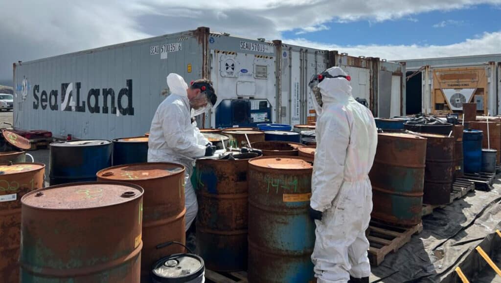 Two men writing on rusty drums